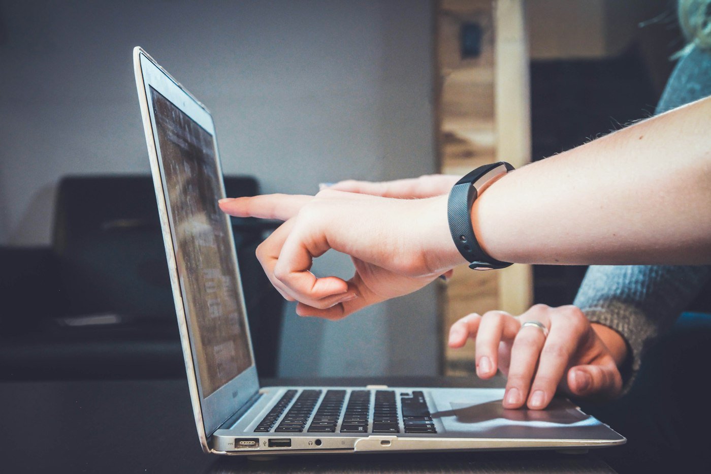 Dwie osoby wskazują ekran laptopa